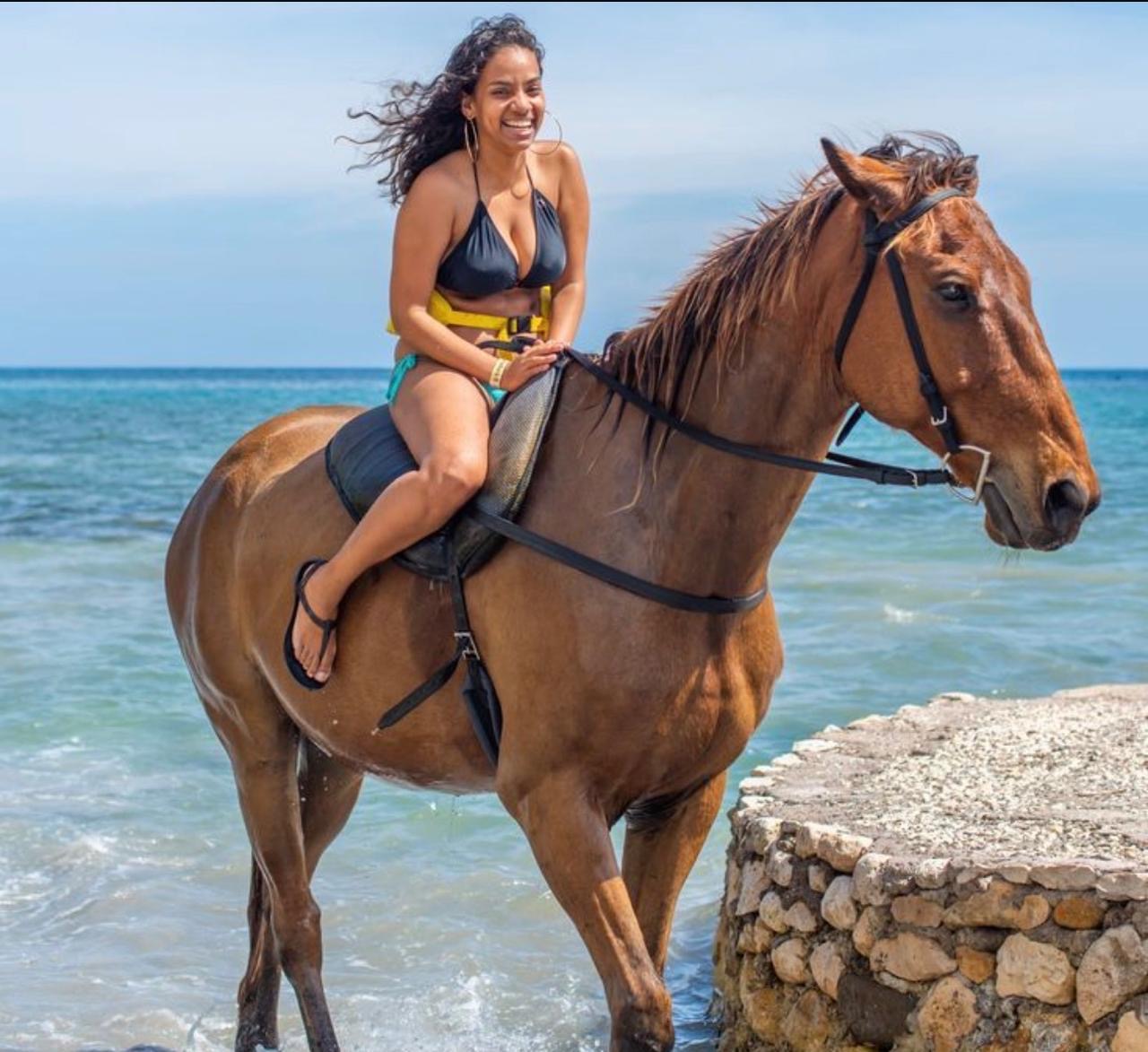 Guest laughing on horseback in the sea