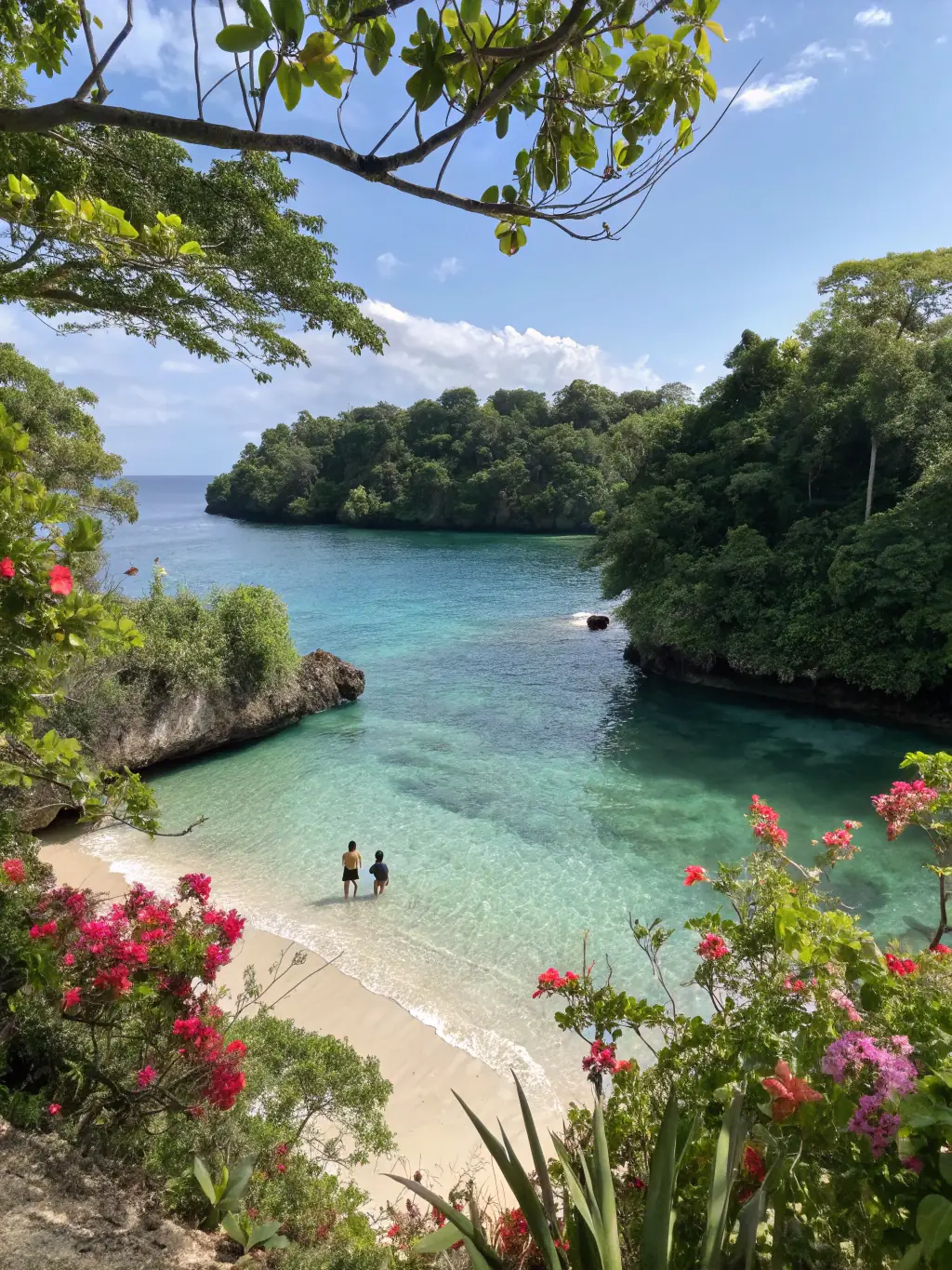 A vibrant photo of Frenchman's Cove in Port Antonio, Jamaica, showing a small, secluded beach where a freshwater river meets the ocean, surrounded by lush greenery.